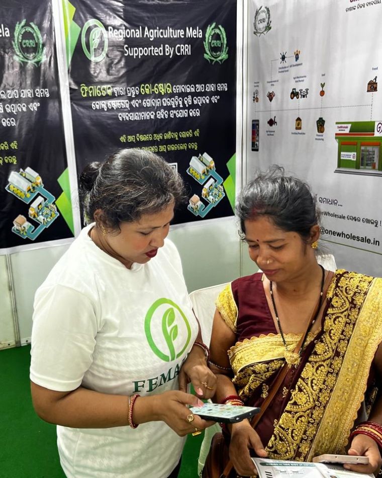 A FEMATEK team member showing the COStore app to a farmer at the Regional Agriculture Mela